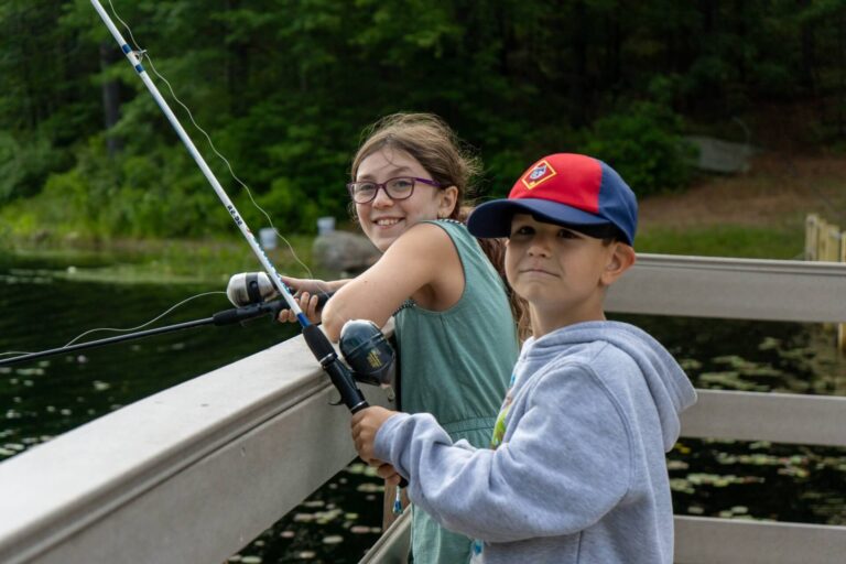 Two young campers fishing from the dock at Camp Carpenter in Manchester, NH