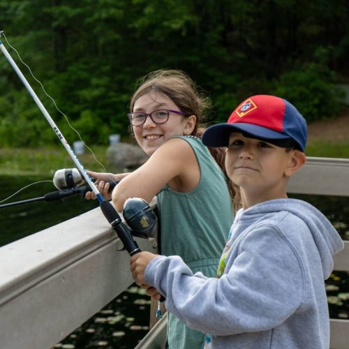 Two young campers fishing from the dock at Camp Carpenter in Manchester, NH